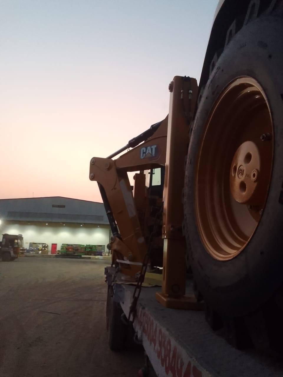 Wheel loader loaded on an MMM semi-low-bed trailer at dusk