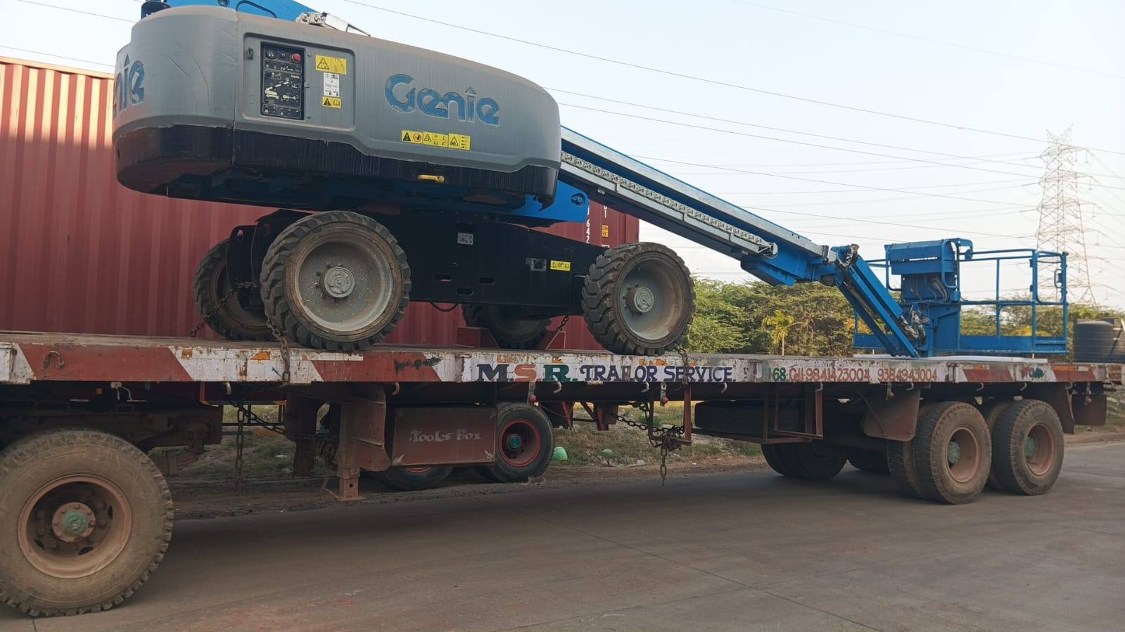 Self-propelled boom lift loaded and secured on a semi-low-bed trailer