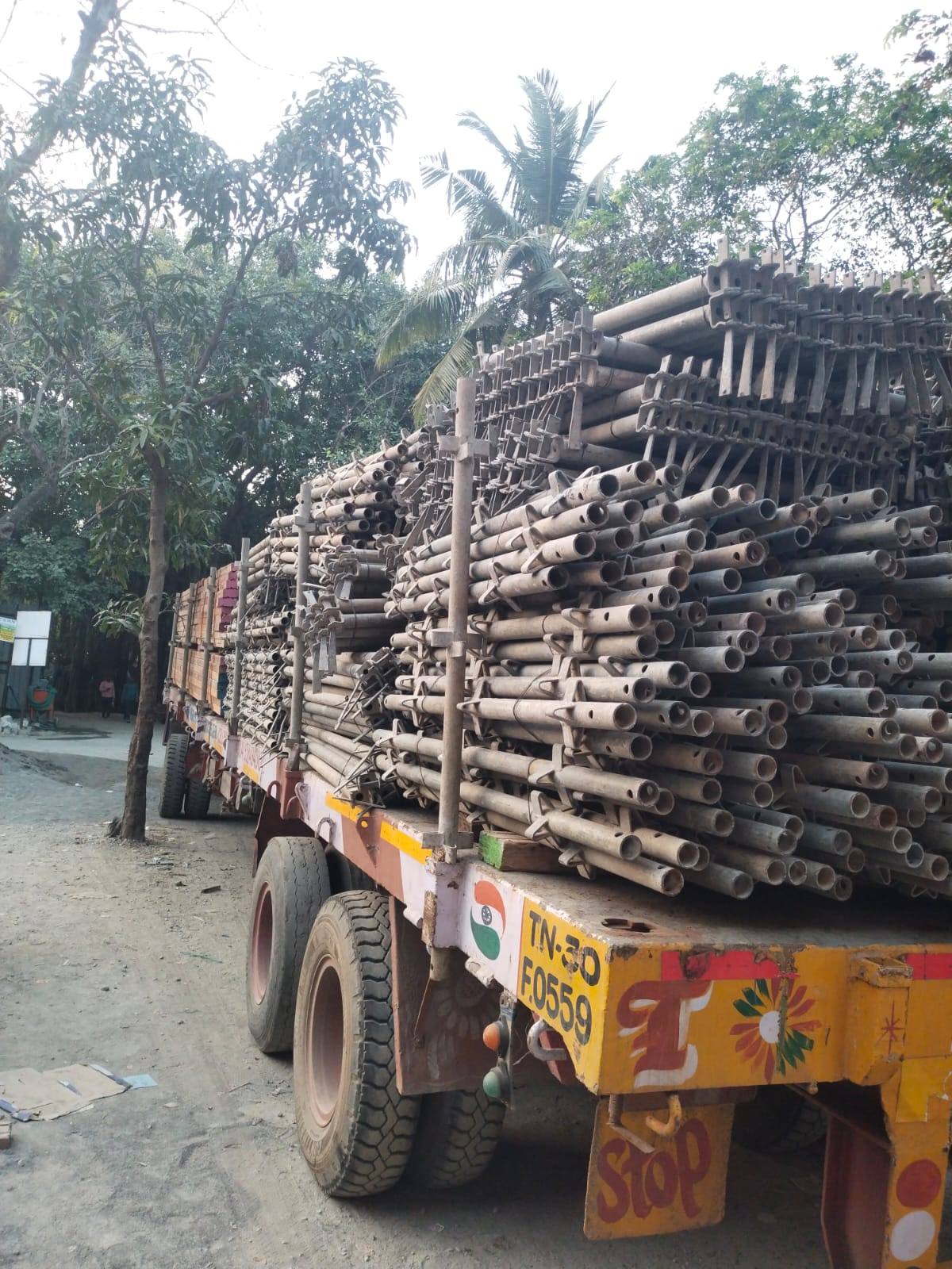 Bundles of scaffolding pipe loaded high on a flatbed trailer