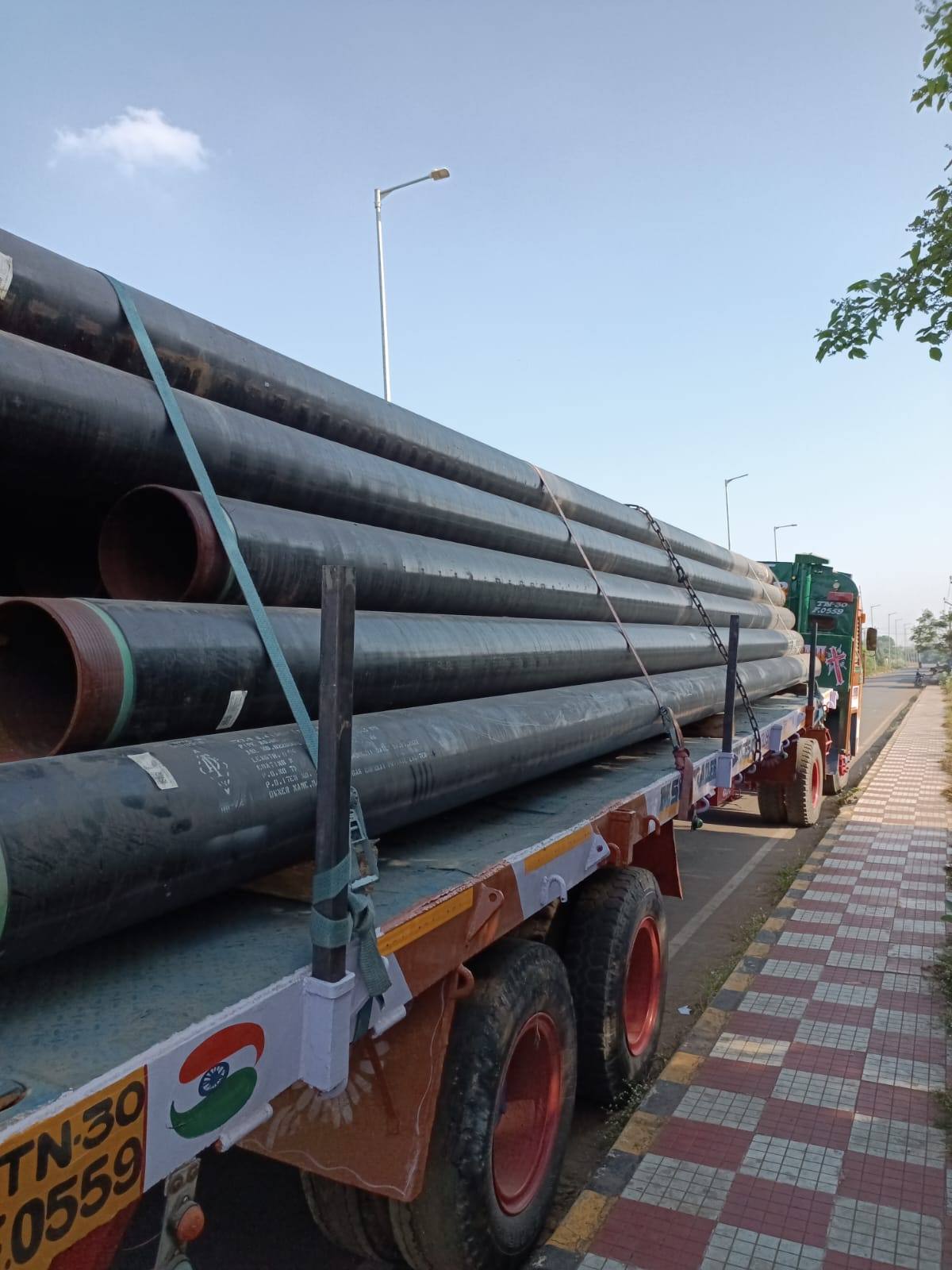 Long steel pipes loaded lengthways on an MMM 40 ft trailer
