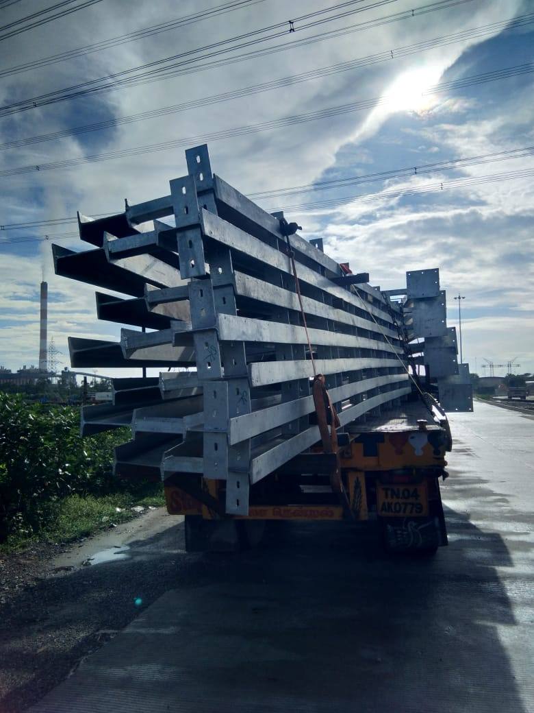 Fabricated structural steel beams loaded on a trailer against the sky
