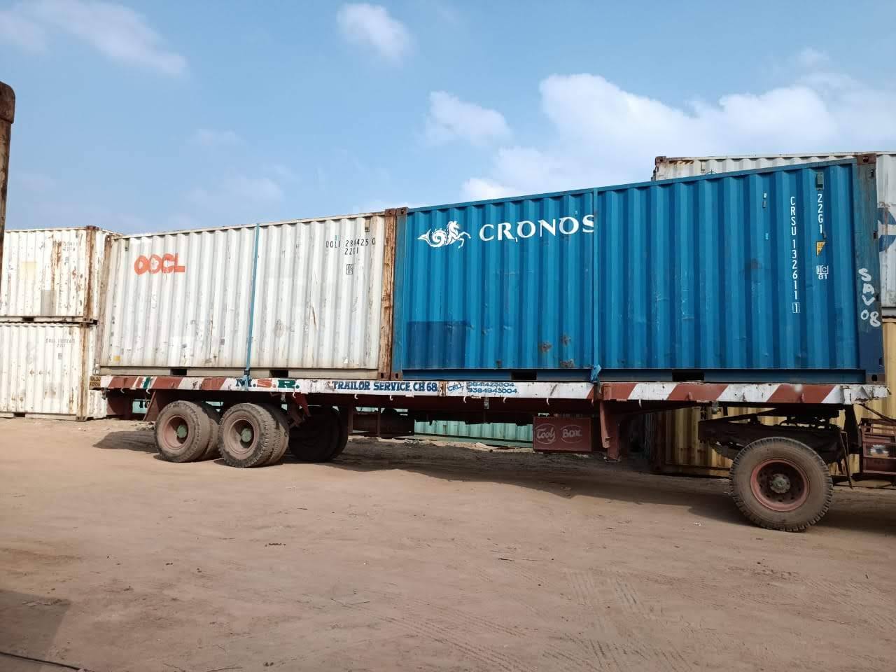 Two 40 ft shipping containers loaded end to end on an MMM trailer in daylight
